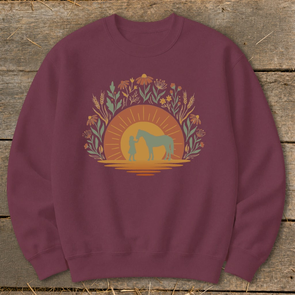 Maroon sweatshirt with a sunset, flowers, a person, and a horse graphic.
