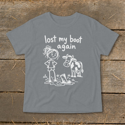 Gray short-sleeved t-shirt with white cartoon graphic of a sad person, cow, and muddy boot with text lost my boot again