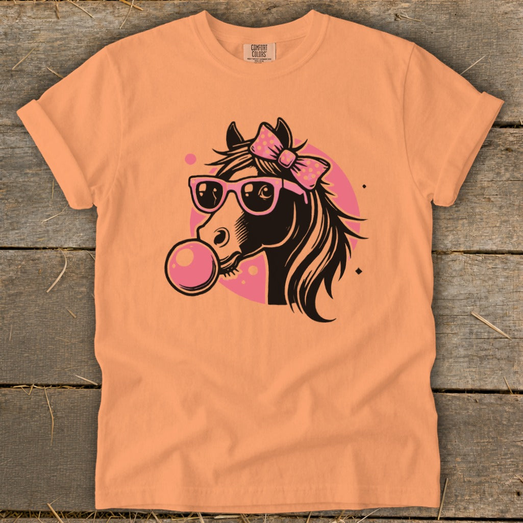Orange t-shirt with a cartoon horse wearing sunglasses and blowing bubblegum.