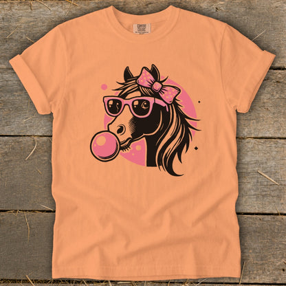 Orange t-shirt with a cartoon horse wearing sunglasses and blowing bubblegum.