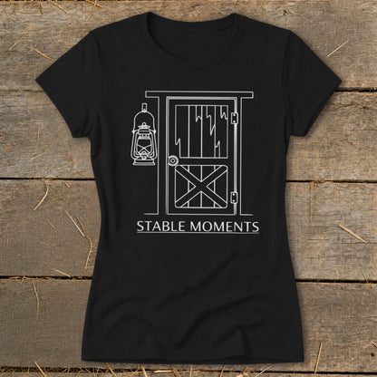 Black t-shirt with white line art of a barn door and hanging lantern, with text "STABLE MOMENTS".
