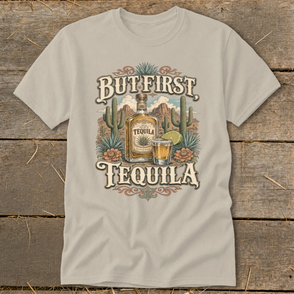 T-shirt graphic with "But First Tequila" text, bottle, shot glass, and desert landscape.