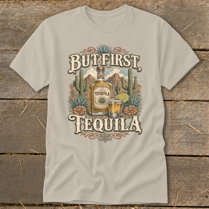 T-shirt graphic with "But First Tequila" text, bottle, shot glass, and desert landscape.