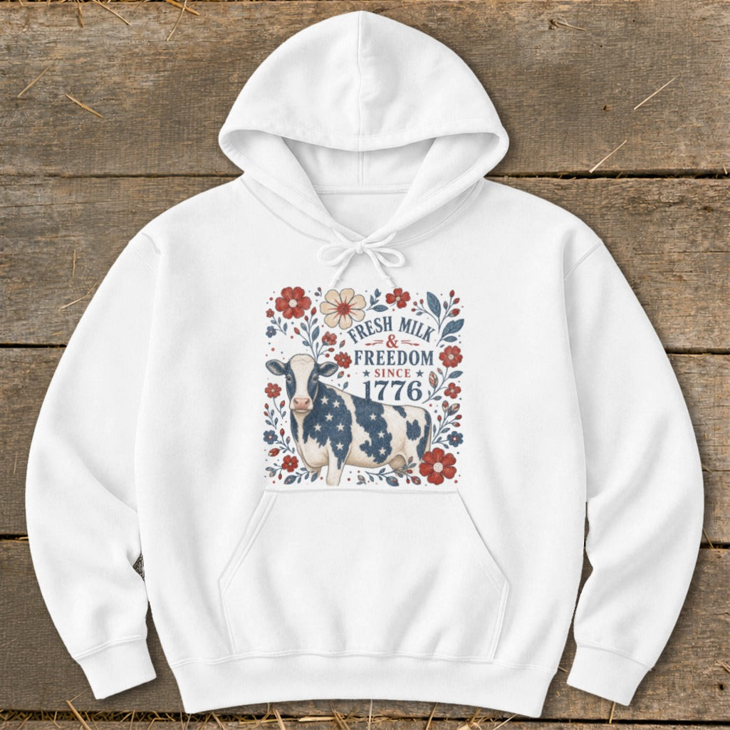 White hoodie with a cow graphic that reads "Fresh Milk & Freedom Since 1776."