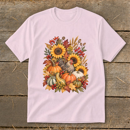 Pink t-shirt with a watercolor design of sunflowers, pumpkins, gourds, leaves, and chickens.