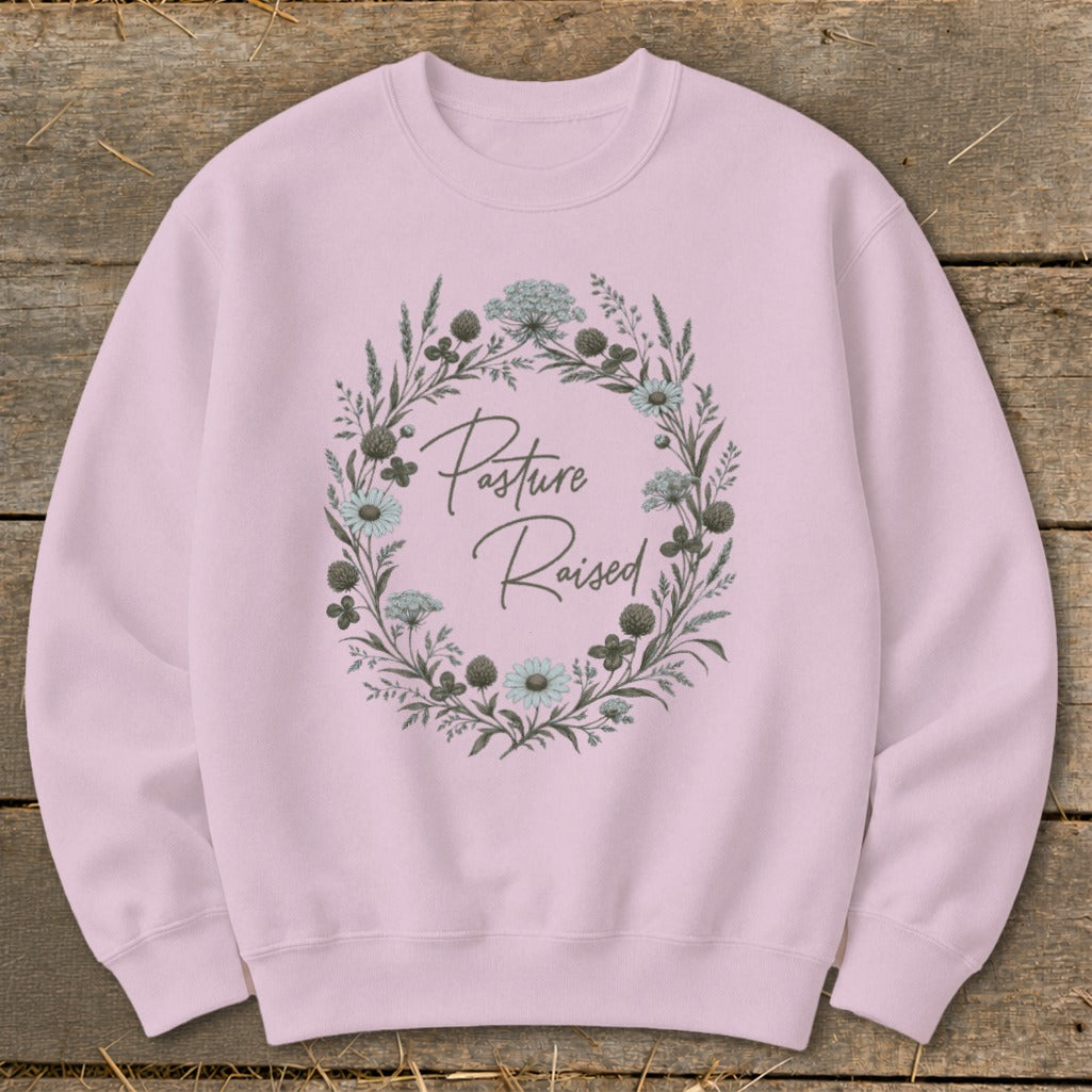 Pink sweatshirt with "Pasture Raised" text inside a floral wreath.