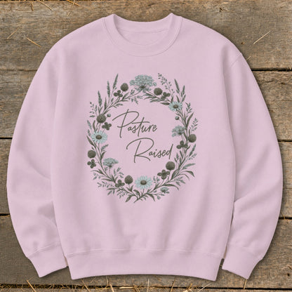 Pink sweatshirt with "Pasture Raised" text inside a floral wreath.