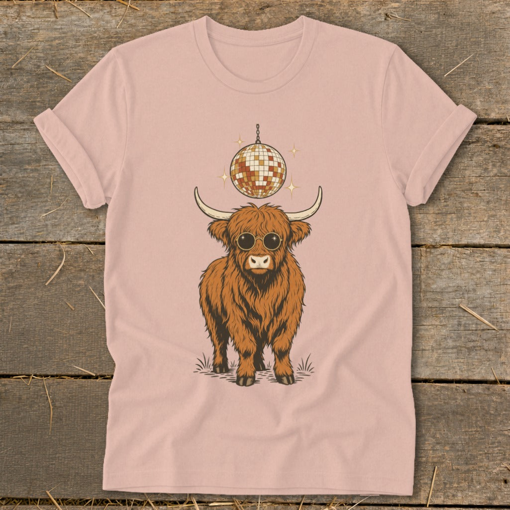 Highland cow wearing sunglasses with disco ball above on pink t-shirt.