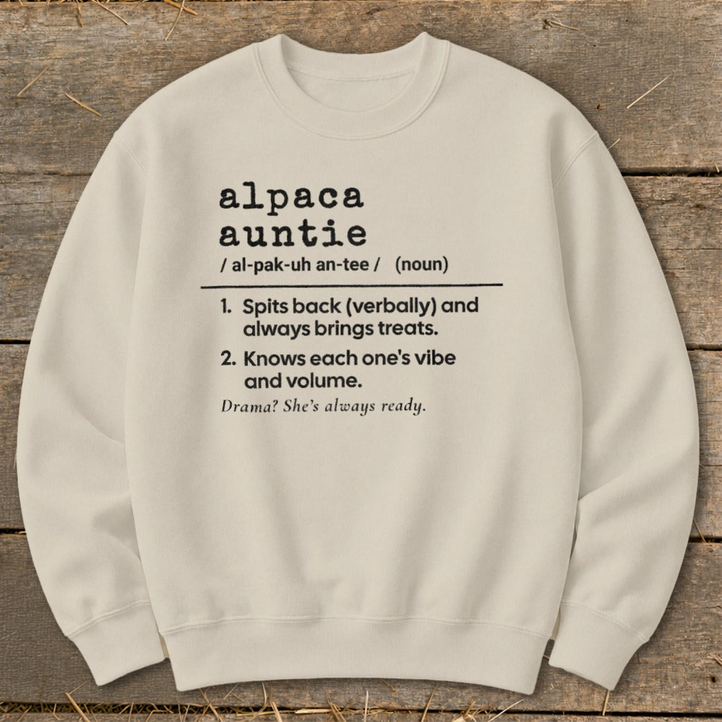 A cream-colored crewneck sweatshirt printed with black text defining the term alpaca auntie.