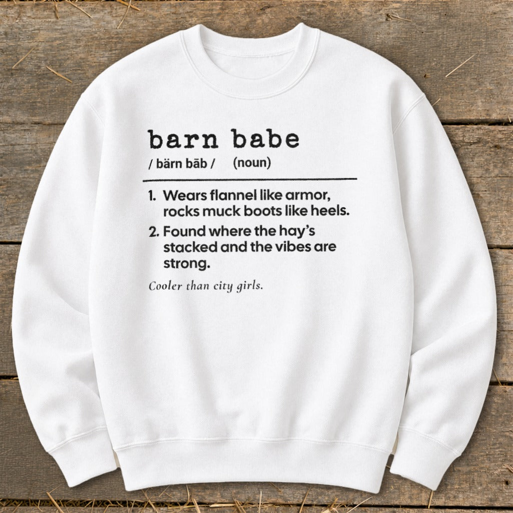 White sweatshirt with "barn babe" definition: "Wears flannel like armor, rocks muck boots like heels. Found where the hay's stacked."