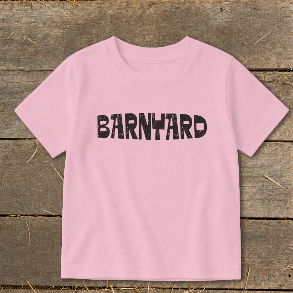 Light pink short-sleeved children's t-shirt featuring the word BARNYARD printed in black distressed lettering across the chest.