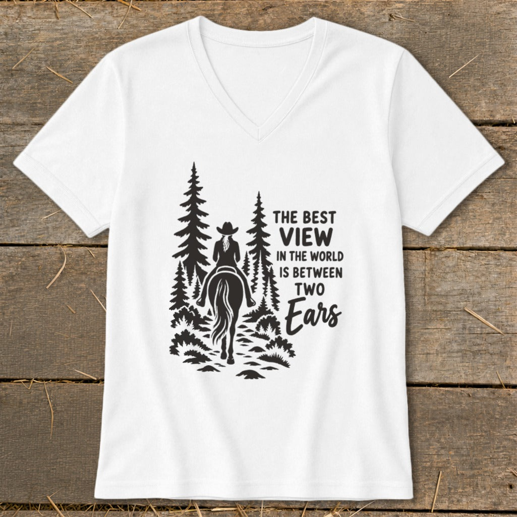 A white V-neck t-shirt with a black graphic of a horse rider in the forest and the text THE BEST VIEW IN THE WORLD IS BETWEEN TWO Ears.