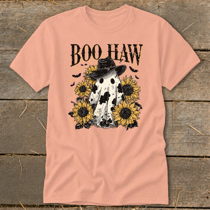 A peach crewneck t-shirt featuring a cow-print ghost in a cowboy hat surrounded by sunflowers and bats, with the text BOO HAW above.