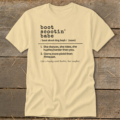 Light yellow t-shirt with "Boot Scootin' Babe" definition, listing qualities and a comparison.