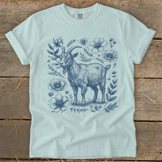 Light blue t-shirt with a sketch of a goat surrounded by blue flowers and foliage.