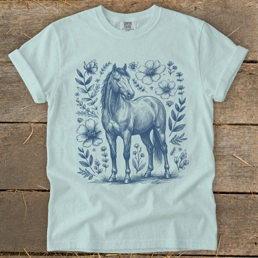 Light blue t-shirt with a sketched horse and floral border design.