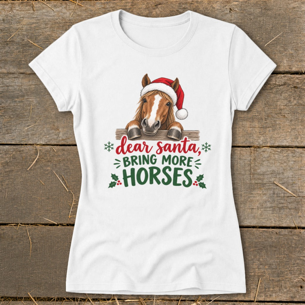 A white t-shirt featuring a horse wearing a Santa hat and text that reads Dear Santa Bring More Horses.