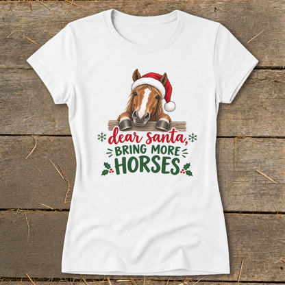 A white t-shirt featuring a horse wearing a Santa hat and text that reads Dear Santa Bring More Horses.