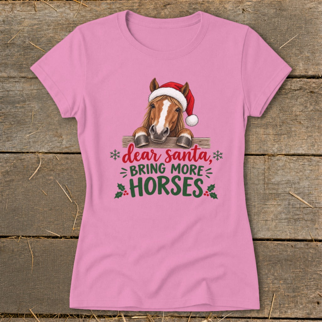 Pink short-sleeved t-shirt featuring a horse in a Santa hat behind a fence with holiday text.