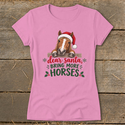 Pink short-sleeved t-shirt featuring a horse in a Santa hat behind a fence with holiday text.