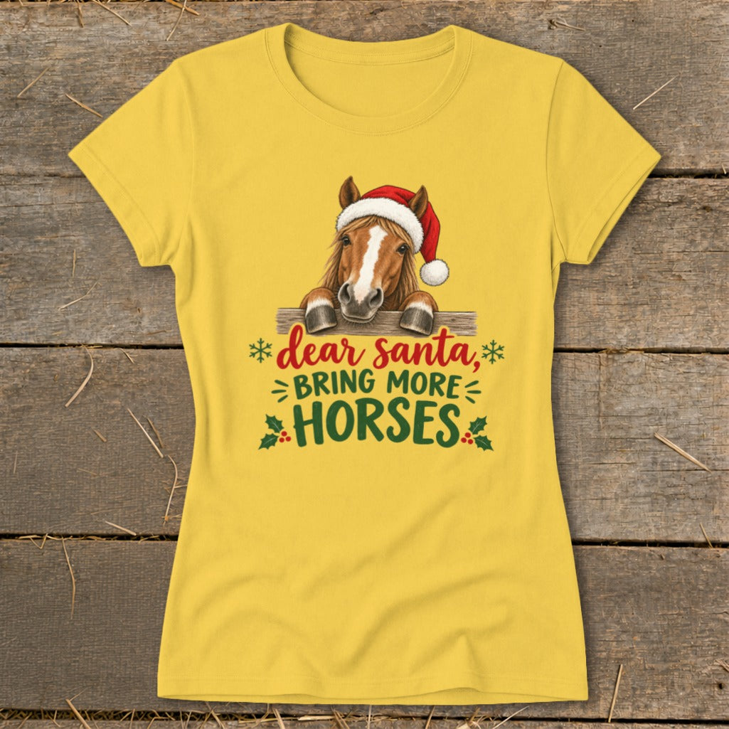 A yellow short-sleeve t-shirt features a graphic of a horse wearing a Santa hat behind a fence with the text "dear santa, BRING MORE HORSES".