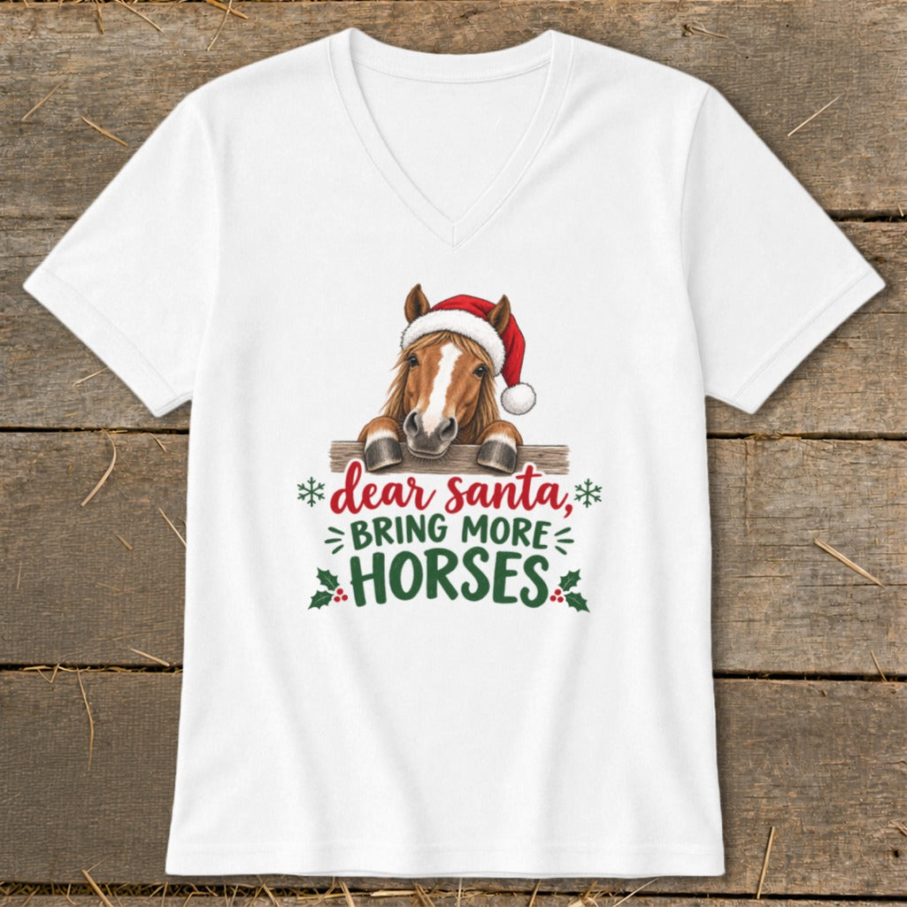 A white V-neck t-shirt featuring a graphic of a horse in a Santa hat leaning over a fence, with the text Dear Santa, Bring More Horses.