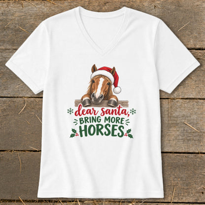 A white V-neck t-shirt featuring a graphic of a horse in a Santa hat leaning over a fence, with the text Dear Santa, Bring More Horses.