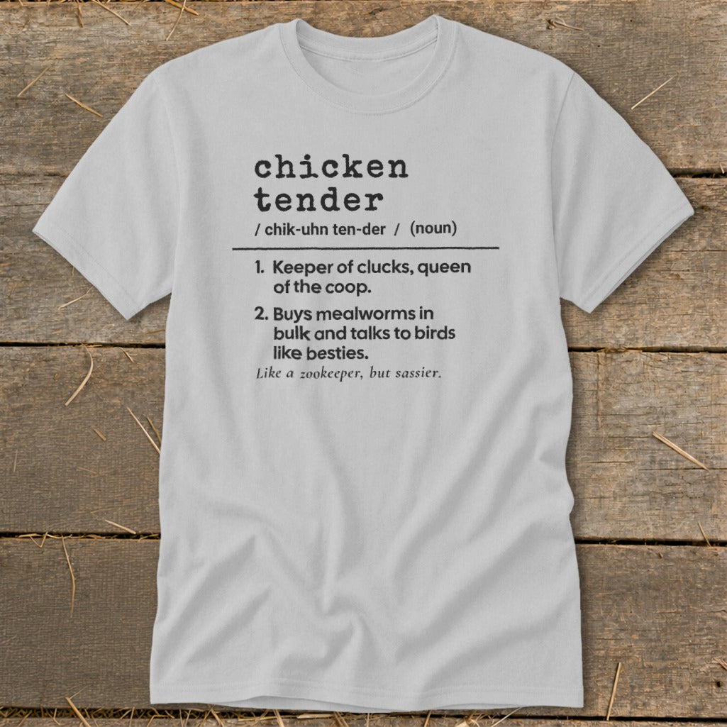 A light gray t-shirt with black text defining the term chicken tender on a wooden background.