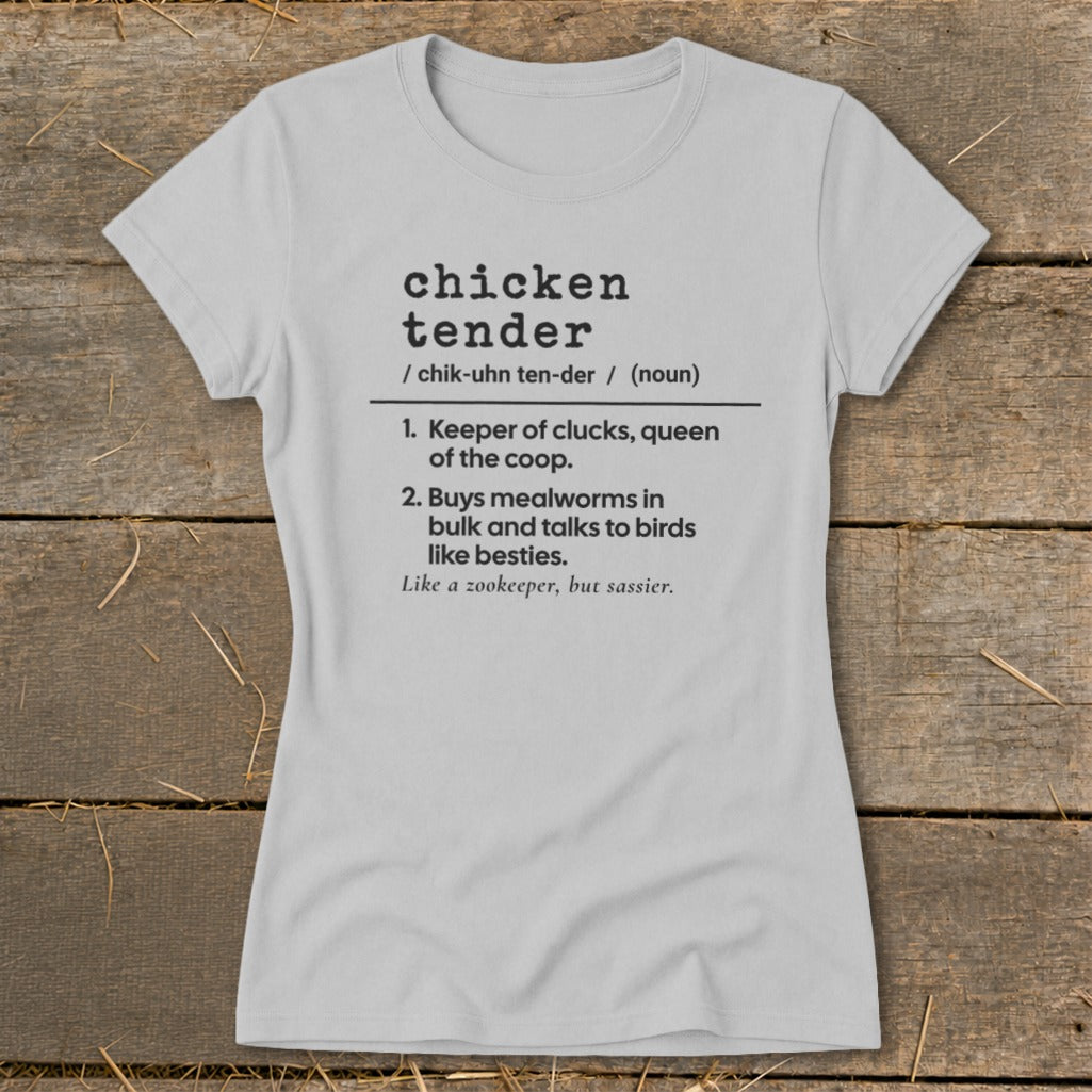 Light gray women's t-shirt printed with a humorous definition of a chicken tender on a rustic wooden background.