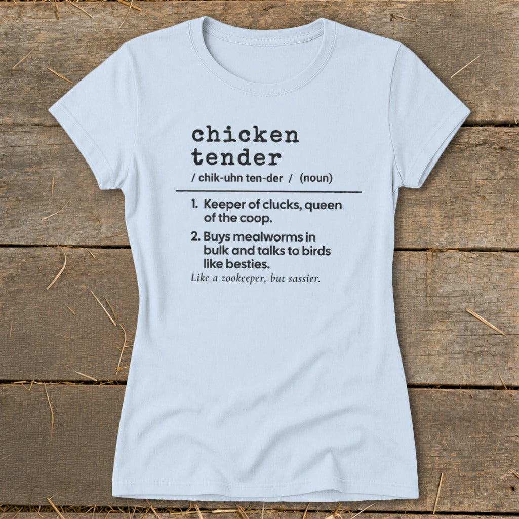 A light blue t-shirt with black dictionary-style text defining chicken tender on a rustic wooden background.