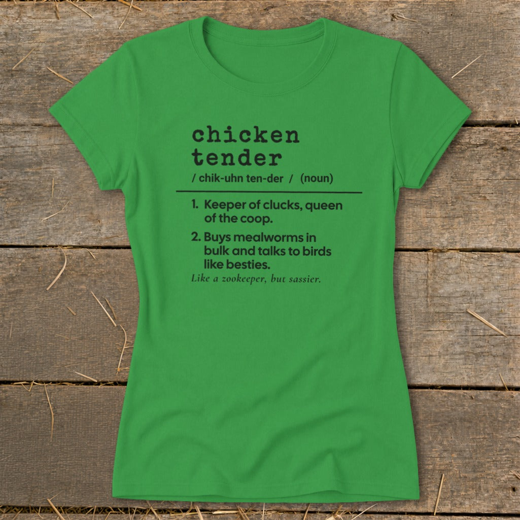 A green crewneck t-shirt with black dictionary-style text that reads "chicken tender" laid flat on a rustic wooden background.