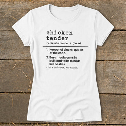A white short-sleeved t-shirt printed with humorous dictionary definition text about chicken tenders on a wooden background.