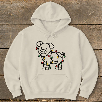 A cream-colored hoodie featuring a graphic of a cartoon pig tangled in colorful Christmas lights.