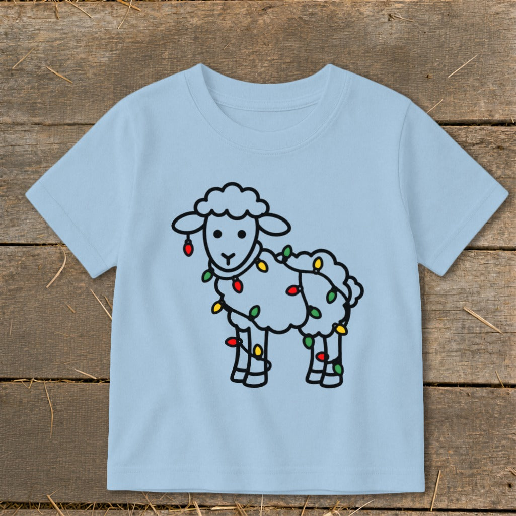 Light blue children's t-shirt featuring a line art graphic of a fluffy sheep tangled in colorful Christmas lights.