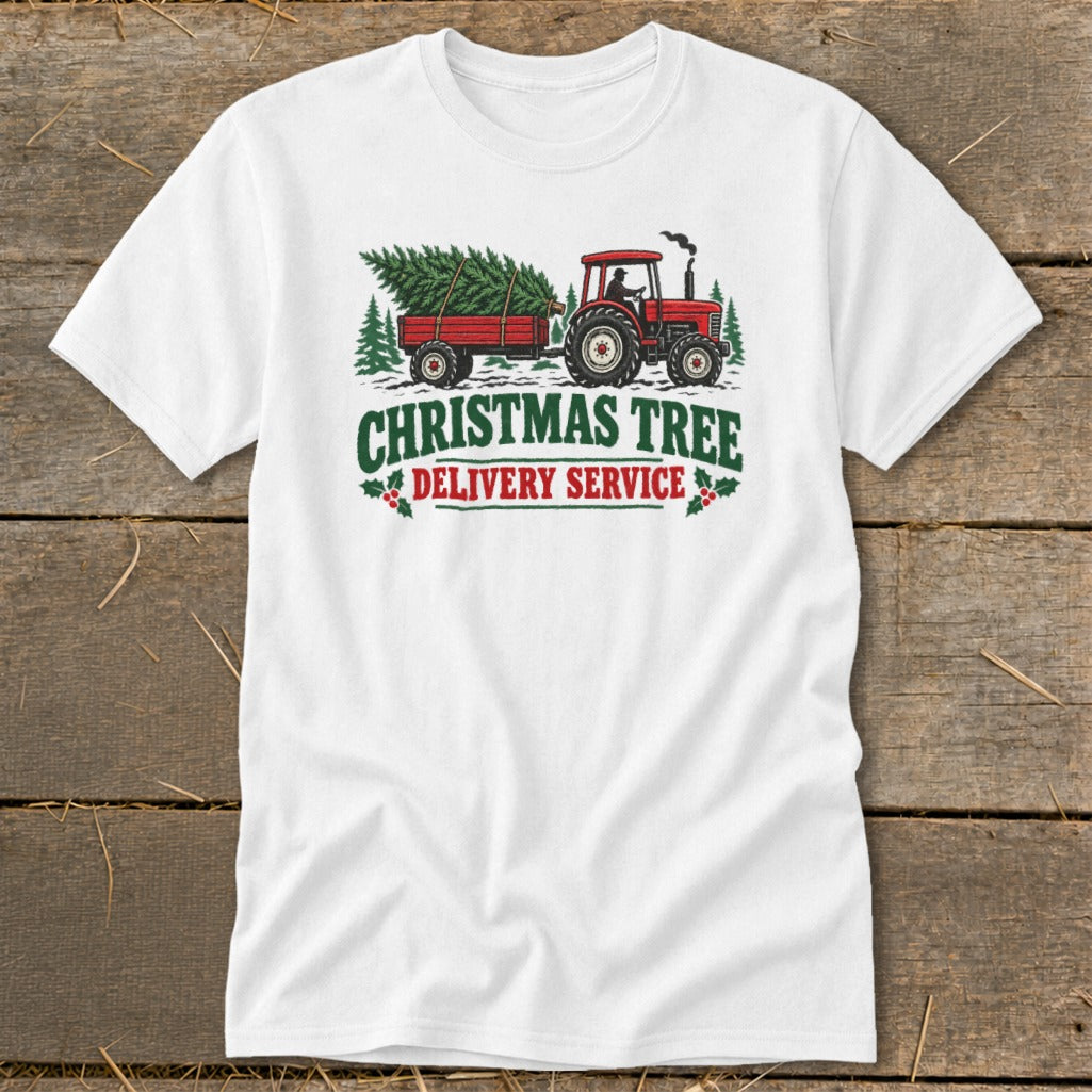 White t-shirt with a red tractor towing a trailer with a Christmas tree, reads "Christmas Tree Delivery Service".