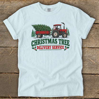 White t-shirt with graphic of red tractor towing Christmas tree in trailer.