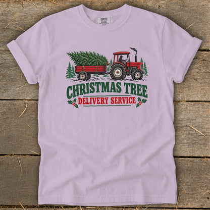 Red tractor pulling a Christmas tree on a trailer with text.