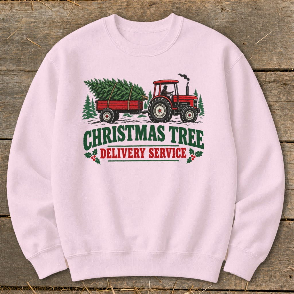 Pink sweatshirt with a red tractor pulling a trailer of Christmas trees and text.