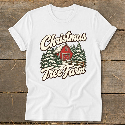 White t-shirt with Christmas Tree Farm graphic featuring red barn and snow-covered pines.