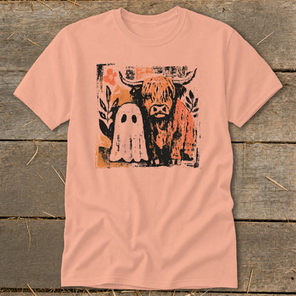Highland cow and ghost graphic on a peach t-shirt with distressed texture.
