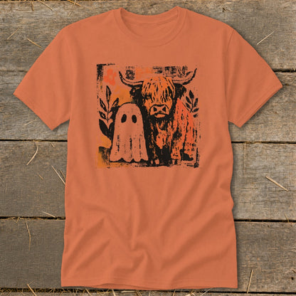 Highland cow and ghost graphic on an orange t-shirt.