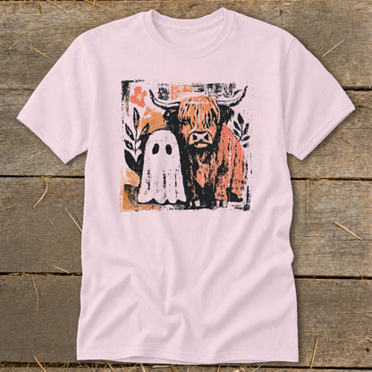 Pink t-shirt with a distressed graphic of a Highland cow and a friendly ghost.