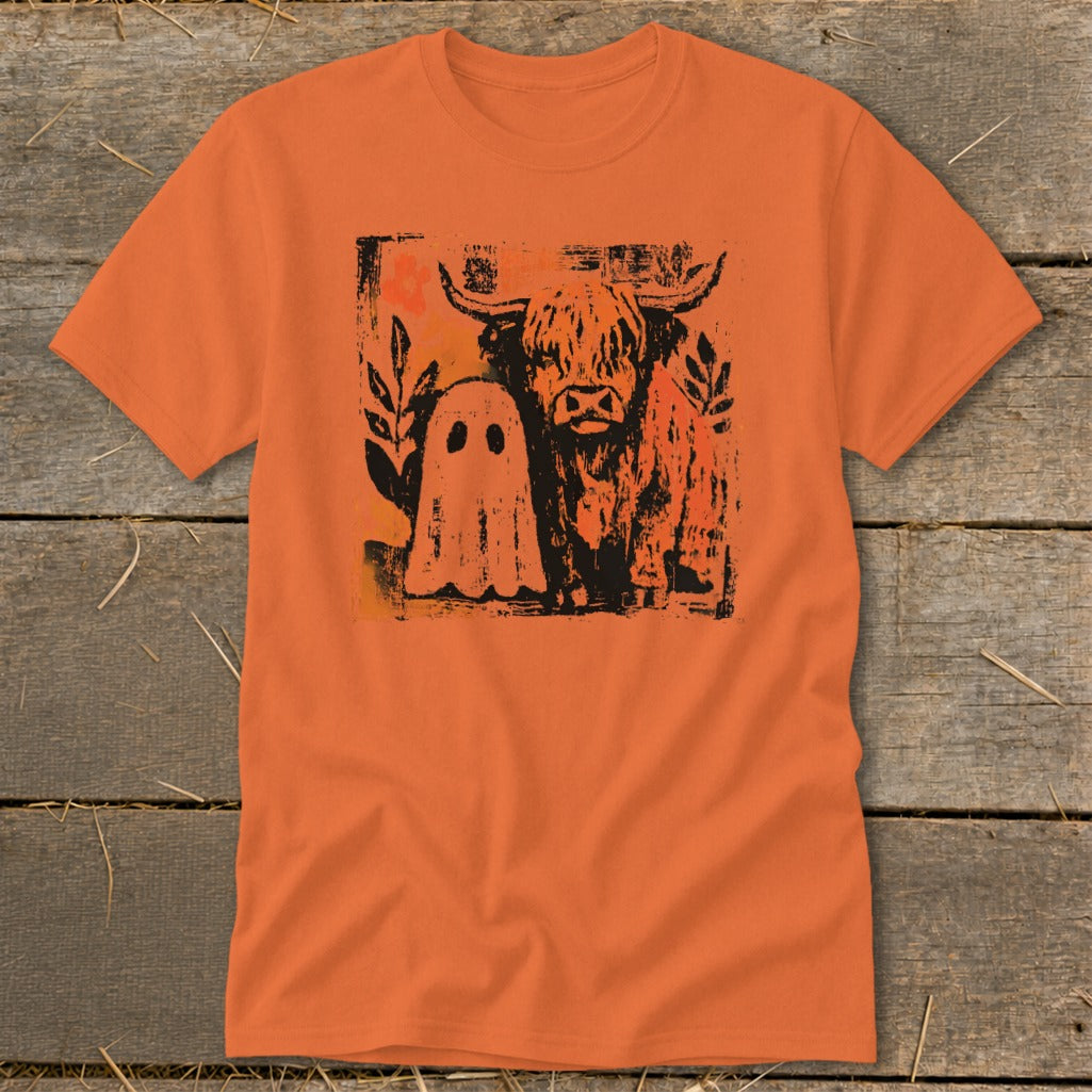 Orange t-shirt with a Highland cow and ghost graphic.