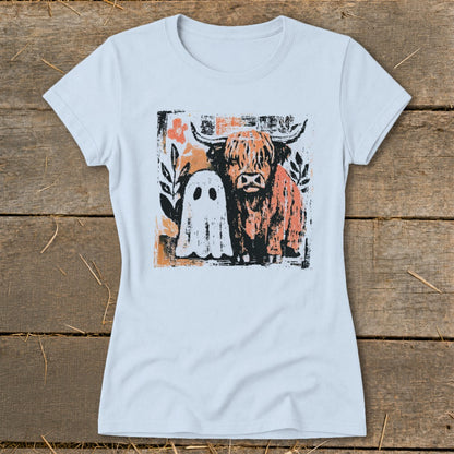 Highland cow and ghost graphic with floral accents on a light blue t-shirt.