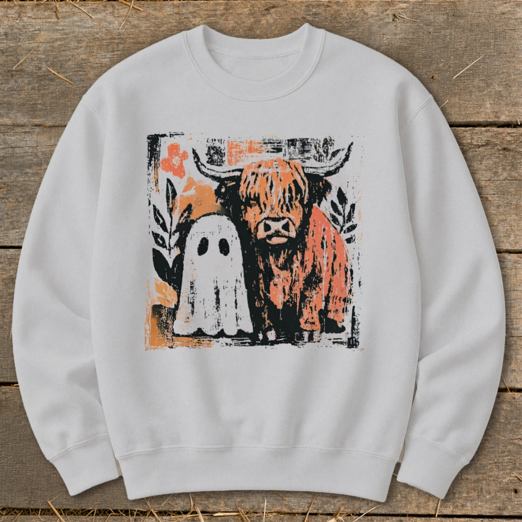 Highland cow and ghost illustration with floral accents on a white sweatshirt.