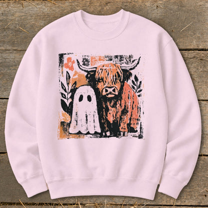 Highland cow and ghost graphic on a pink crewneck sweatshirt.