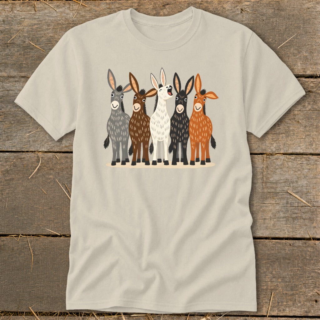 A light cream t-shirt features a graphic illustration of five colorful, cartoon-style donkeys standing in a row on a wooden background.
