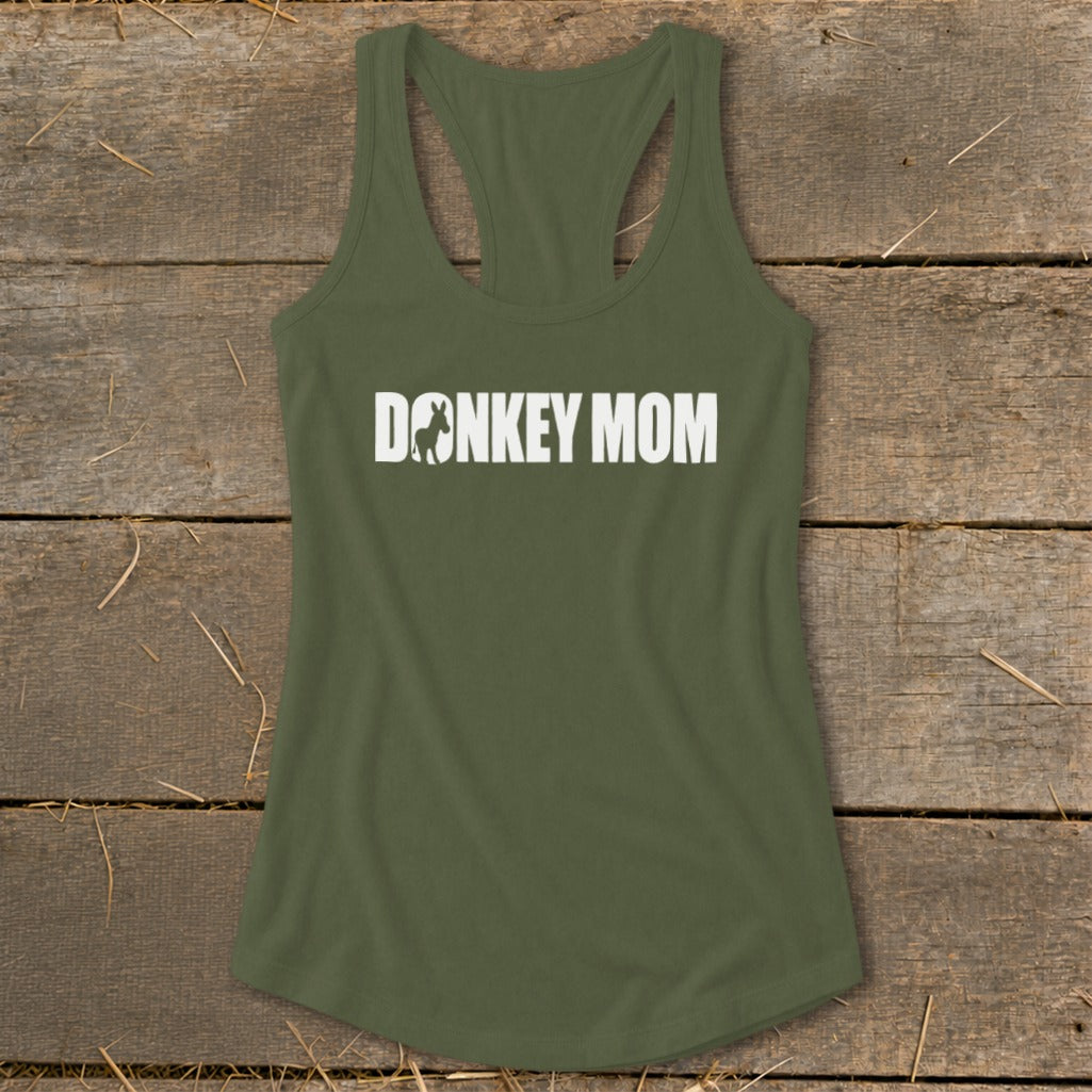 Olive green racerback tank top with white Donkey Mom text centered on the chest, lying flat on a wooden surface.