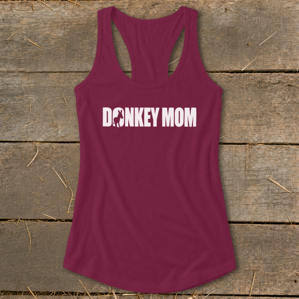 Maroon racerback tank top featuring white Donkey Mom text with a donkey silhouette on a wooden background.