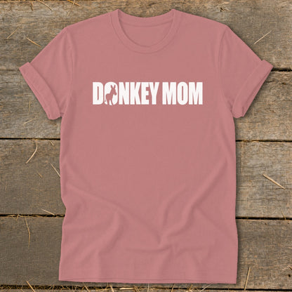 Dusty pink t-shirt with rolled sleeves displaying white text reading DONKEY MOM with a donkey silhouette inside the letter O.